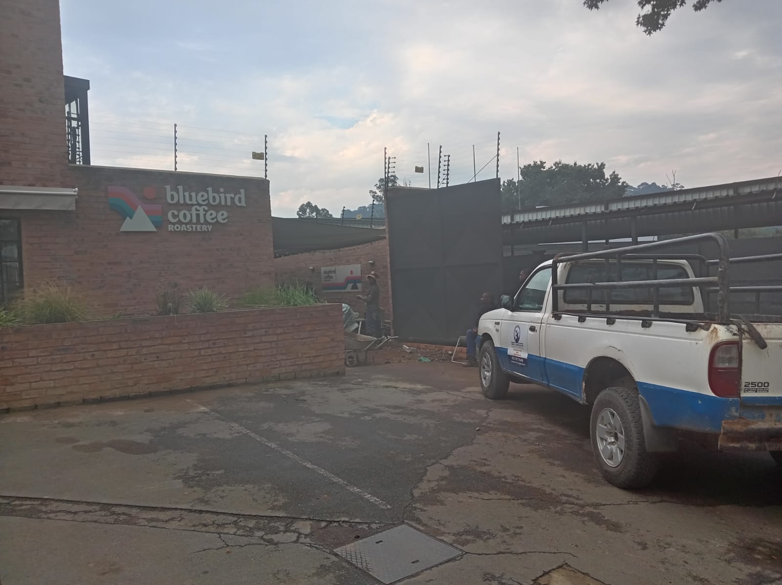 Construction team and work vehicle at a commercial property entrance
